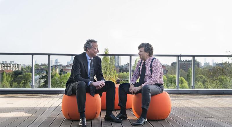 Two man are talking each other on top of the building 