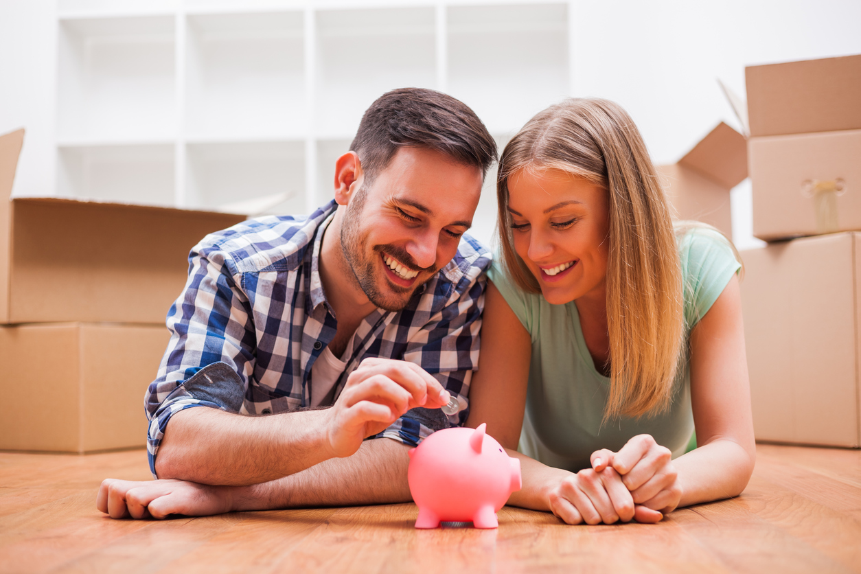 Couple are putting a coin inside the piggy bank