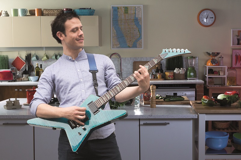 Man is playing his guitar in front of the camera