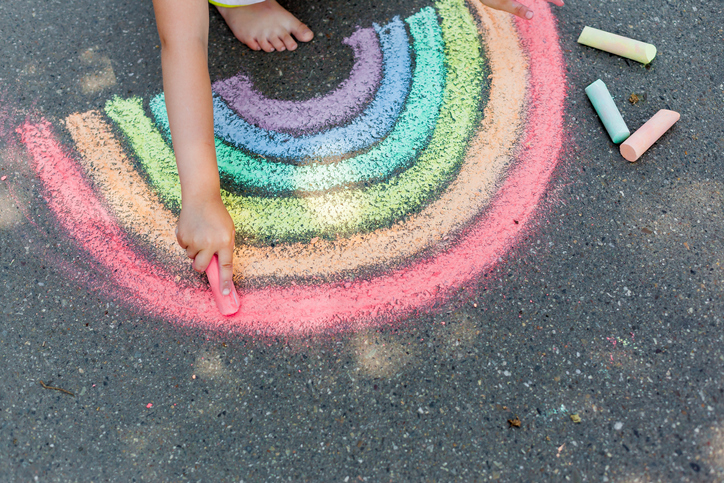 Kid is playing wit his chalk on the floor